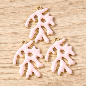 Detail van roze koraal emaille bedeltjes met vergulde randen voor het maken van sieraden