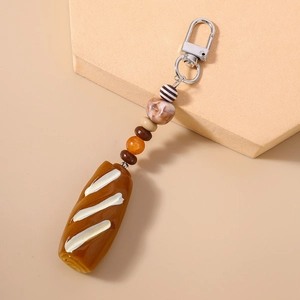 Close-up of creative faux baguette charm with decorative beads and silver lobster clasp