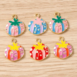 Macro shot of colorful enamel pumpkin pendants with gold loops for DIY jewelry making