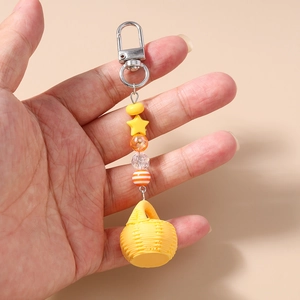Detail of beaded keychain featuring a yellow woven basket charm and star-shaped beads