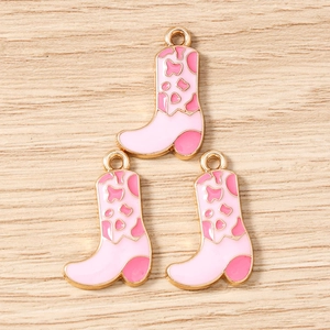 Detailed view of pink cow print cowboy boot charms for DIY jewelry making