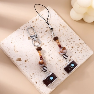Detail of beaded camera keychain with turquoise beads and retro miniature camera charm