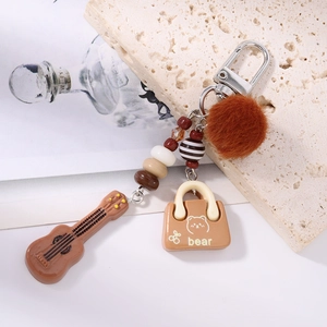 Detailed shot of creative guitar pendant keychain with brown pom pom and beaded charms
