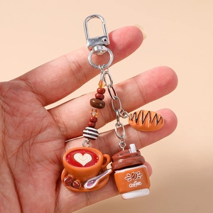 Detail of coffee keychain with latte cup heart art and miniature croissant charm