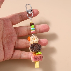 Gros plan d'un porte-clés brochette de nourriture réaliste avec crevettes et perles