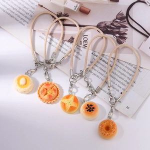 Detailed close-up of colorful resin food charms like donuts and tarts with metal clasps