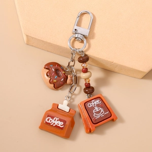 Detailed close-up of a coffee and donut themed metal keychain with a lobster clasp