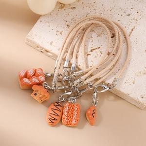 Detailed view of 5-piece realistic miniature bread charms with woven phone straps