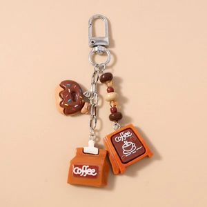 Detailed close-up of resin coffee charms with donut and coffee bean bag on metal keychain