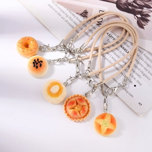 Detailed close-up of realistic resin donut and pastry charms with cream woven lanyards