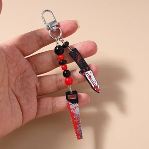 Detail of Halloween beaded keychain with blood-splatter effect knife and saw charms