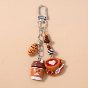 Detailed close-up of coffee theme keychain with mini cup, croissant and beads detail