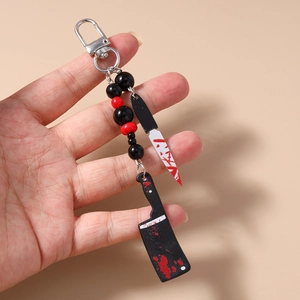 Detail of bloody horror knife keychains with red and black beads for Halloween