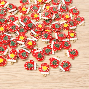 Detail view of red Christmas glove charms with tree and bell patterns for DIY jewelry