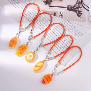 Macro detail of various realistic resin bread charms with colorful woven cords
