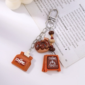 Detail of coffee resin keychain featuring mini coffee bag and chocolate donut charm