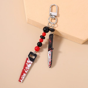 Macro shot of Halloween keychain with bloody saw and knife charms on a display stand