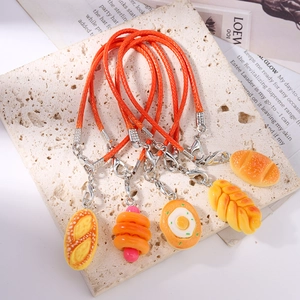 Close-up of five realistic hot dog and pastry phone charms with orange braided lanyards