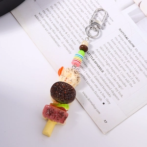 Détail d'un porte-clés burger et brochette de bacon avec perles et crochet métallique