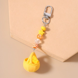 Close-up of beaded keychain with yellow star, orange beads and mini woven basket charm