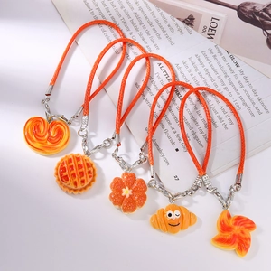 Five assorted creative bread and pastry food charms with bright orange braided lanyards