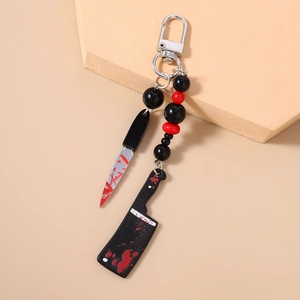 Macro shot of Halloween keychain featuring blood-stained mini knives and red beads