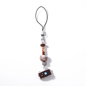 Macro shot of boho beaded phone strap featuring a vintage camera pendant and marble beads