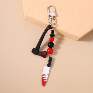 Macro detail of Halloween keychain with bloody axe and knife pendants and red beads