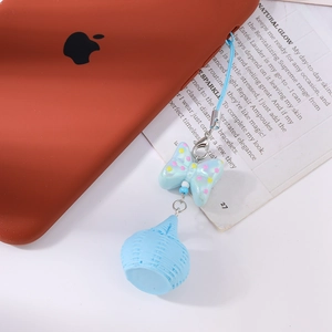 Détail d'un nœud papillon bleu clair et d'une breloque panier pour cordon de portable
