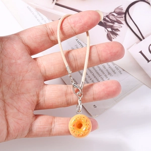 Detailed close-up of a realistic orange donut pendant with colorful sprinkles and a silver clasp