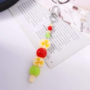 Détail macro du porte-clés brochette de fruits colorés avec perles et fermoir métallique