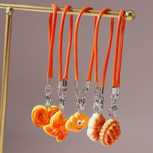 Detailed set of five resin food charms featuring croissant and waffle on orange ropes