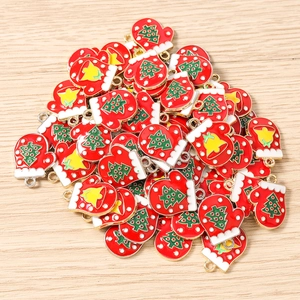 Detailed macro view of red and white Christmas glove enamel charms with gold metal edges