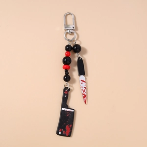 Detail view of Halloween beaded keychain featuring blood-stained knife and meat cleaver charms