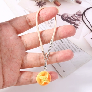 Detail of creative bread charm with star pattern, beige woven strap and silver clasp