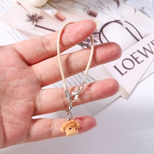 Close-up of mini cupcake phone charm with woven lanyard and silver metal clasp