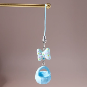 Détail du pendentif téléphone avec nœud bleu et panier tissé sur support doré
