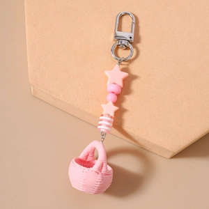 Close-up of pink woven basket keychain with star beads and silver lobster clasp