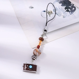 Detail view of retro camera phone charm featuring mixed beads and turquoise accents