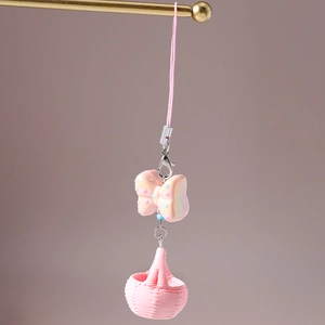 Vue détaillée du porte-clés à nœud rose avec charm panier macaron et fermoir doré
