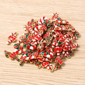 Detailed view of metal Christmas candy cane pendants with red bows for DIY jewelry making