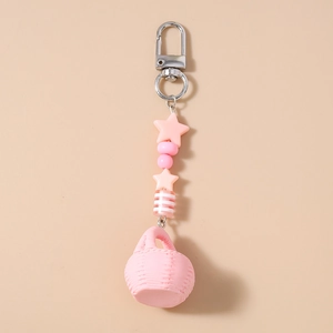 Pink woven basket keychain with star beads and silver lobster clasp on a beige background
