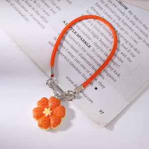 Close-up of orange braided cord and textured orange flower pendant keychain detail