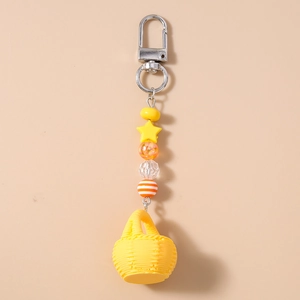Detail of yellow star bead and miniature woven basket keychain with metal lobster clasp
