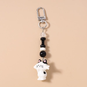 Detail of cute black and white tuxedo cat keychain with striped beads and silver lobster clasp
