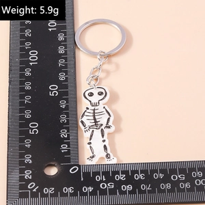 Macro detail of cartoon skull skeleton keychain with silver ring and size measurement