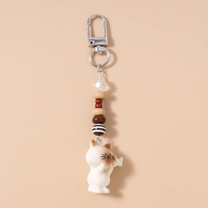 Detail of striped beaded keychain featuring a cute ceramic cat charm and silver lobster clasp