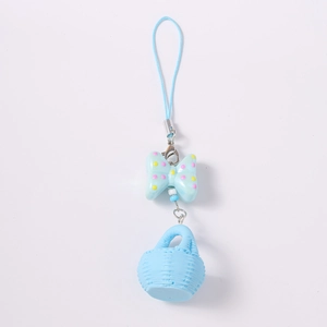 Détail du nœud bleu clair et du pendentif panier tressé sur un porte-clés métallique