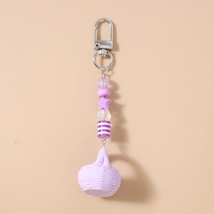 Detail view of purple beaded keychain with star charm and mini woven basket pendant