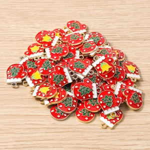 Detail of red enamel Christmas mitten charms with tree and bell patterns for DIY jewelry